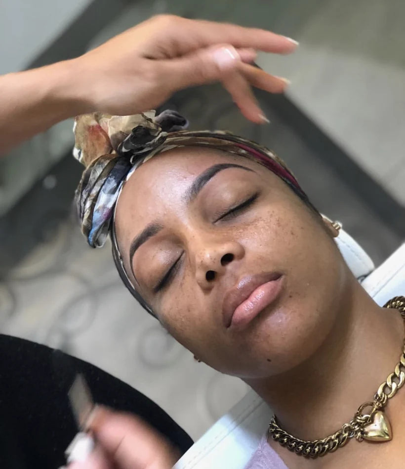 Candy shaping a client's brows during a wax and tint service